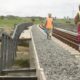 Workers pass by a vandalised section of the railway.