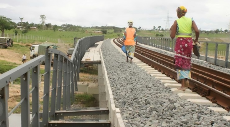 Workers pass by a vandalised section of the railway.