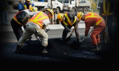 Workers pour bitumen on a road