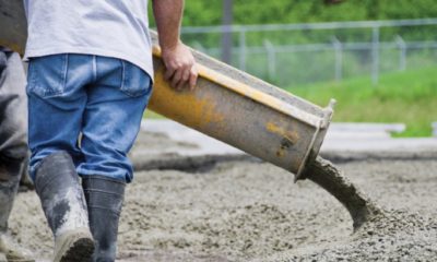 A worker pours concrete at construction site.