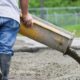 A worker pours concrete at construction site.