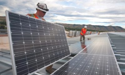 Workers arrange solar panels on-site.