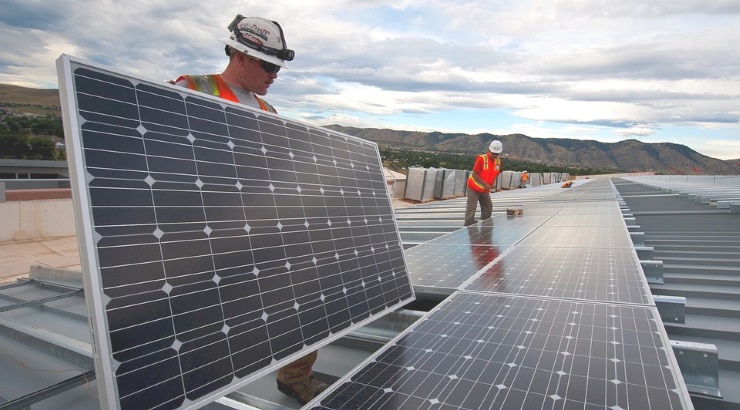 Workers arrange solar panels on-site.