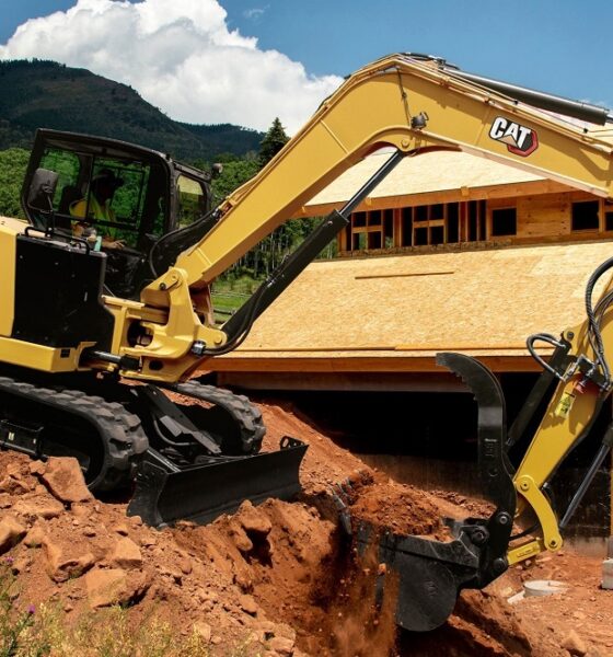 A Caterpillar 308CR mini excavator with long-stick attachment, shown on a construction site.