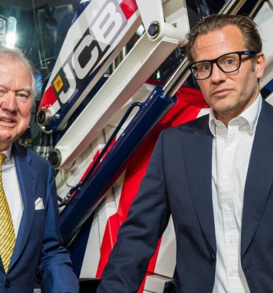 Lord Bamford stands with his son George Bamford (right), discussing succession at JCB.