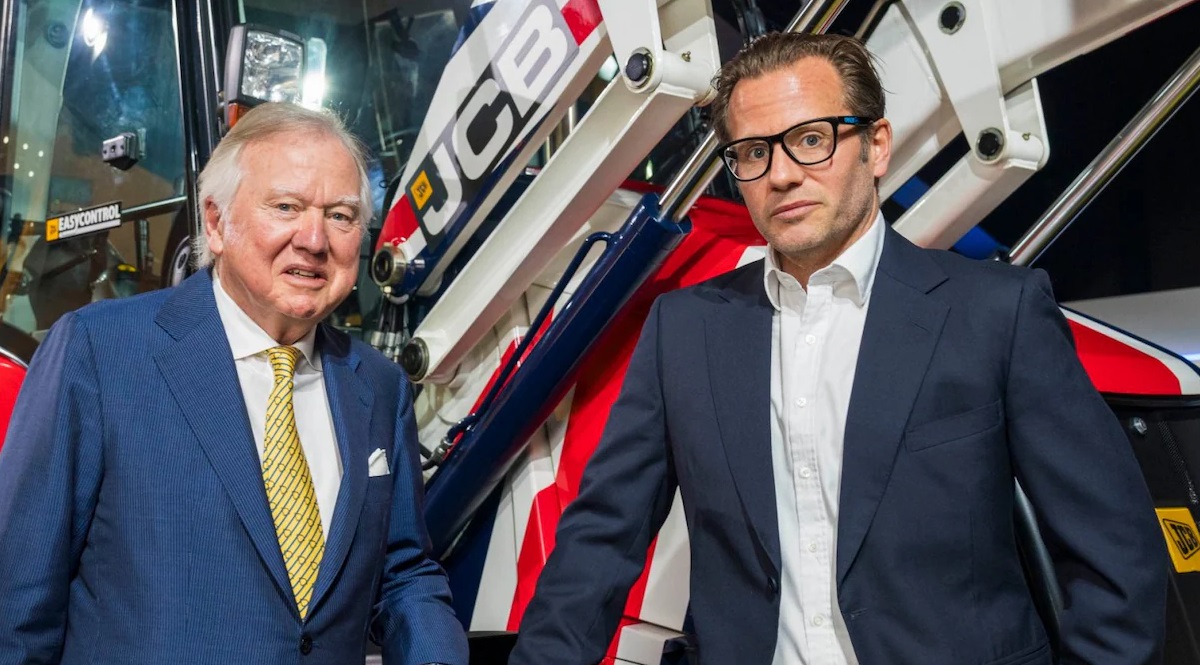 Lord Bamford stands with his son George Bamford (right), discussing succession at JCB.